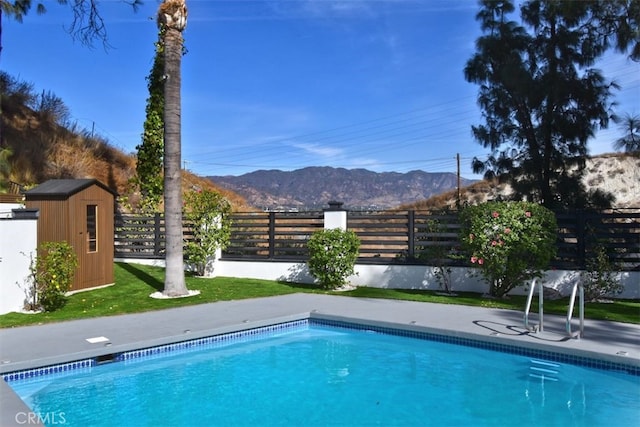 view of pool with a mountain view and a shed