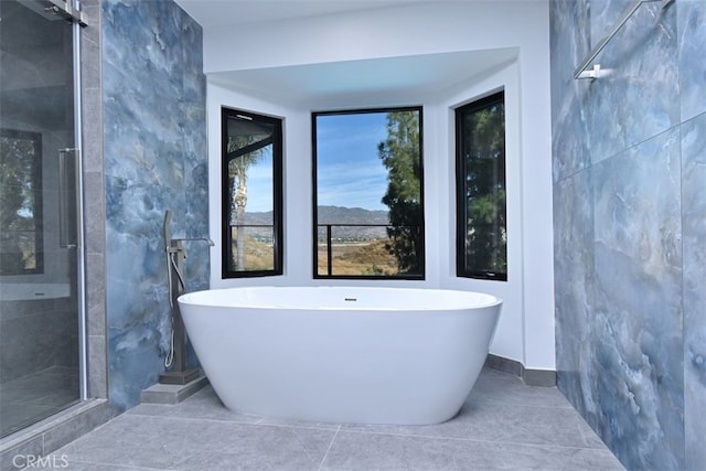 bathroom with tile patterned floors, tile walls, and independent shower and bath