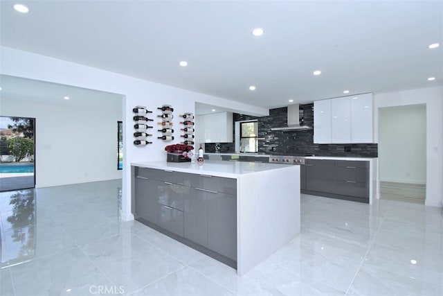 kitchen featuring backsplash, white cabinetry, and wall chimney range hood