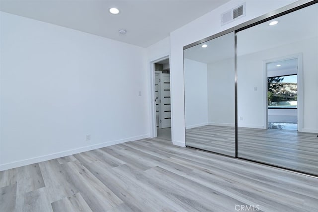 unfurnished bedroom featuring light hardwood / wood-style floors and a closet