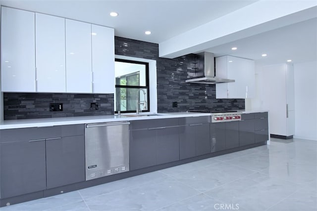 kitchen featuring white cabinets, wall chimney range hood, and appliances with stainless steel finishes