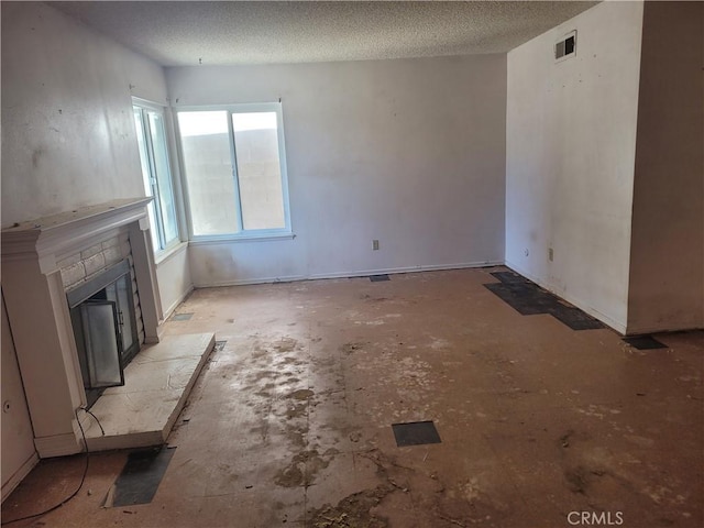 unfurnished living room featuring a fireplace and a textured ceiling