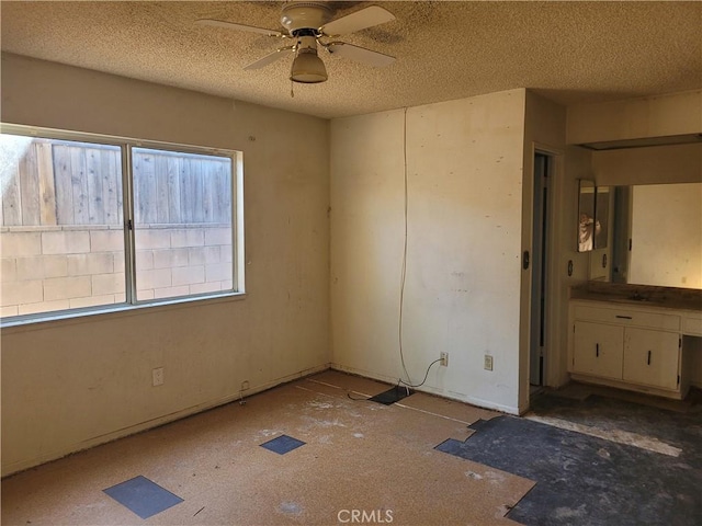 empty room featuring a textured ceiling and ceiling fan