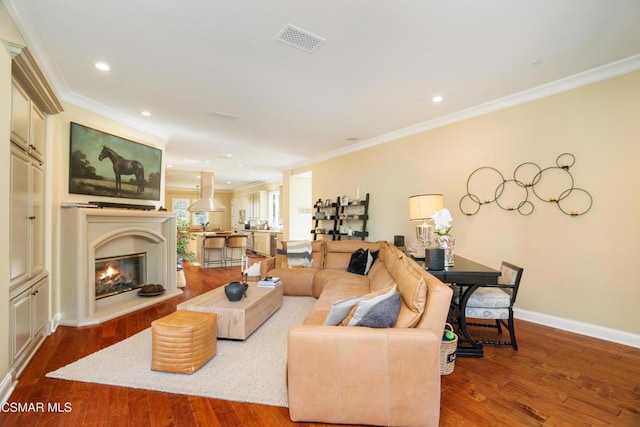 living room with hardwood / wood-style flooring and crown molding