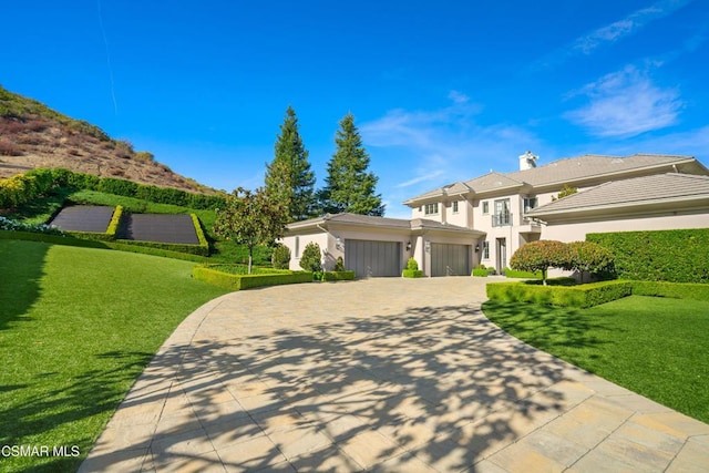 view of front of property with a garage and a front lawn