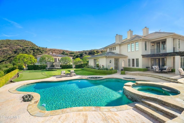 view of swimming pool with a patio area and an in ground hot tub