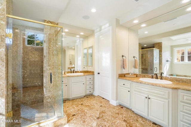 bathroom featuring an enclosed shower, vanity, and a wealth of natural light