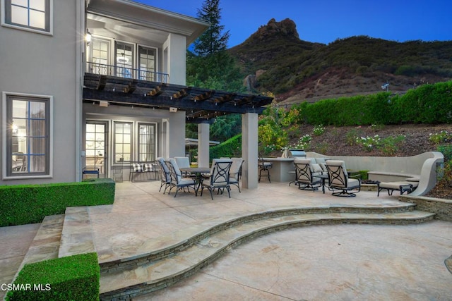 view of patio featuring a mountain view and a balcony