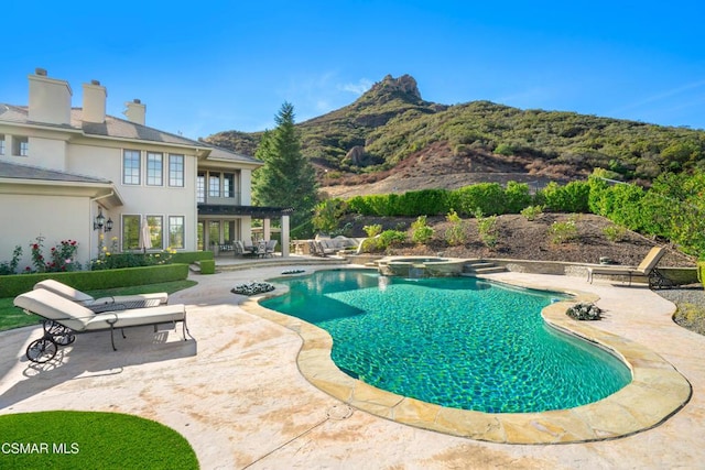 view of swimming pool featuring an in ground hot tub, a mountain view, and a patio