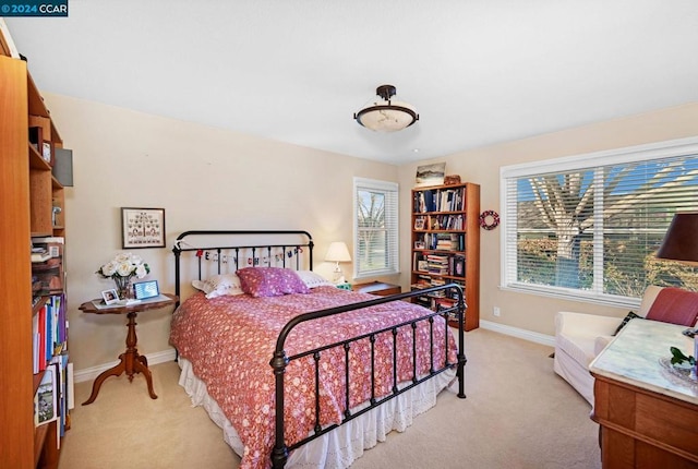 carpeted bedroom featuring multiple windows