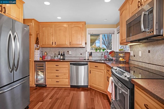 kitchen featuring sink, beverage cooler, dark hardwood / wood-style flooring, decorative backsplash, and appliances with stainless steel finishes