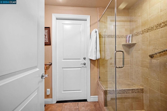 bathroom with tile patterned flooring and an enclosed shower