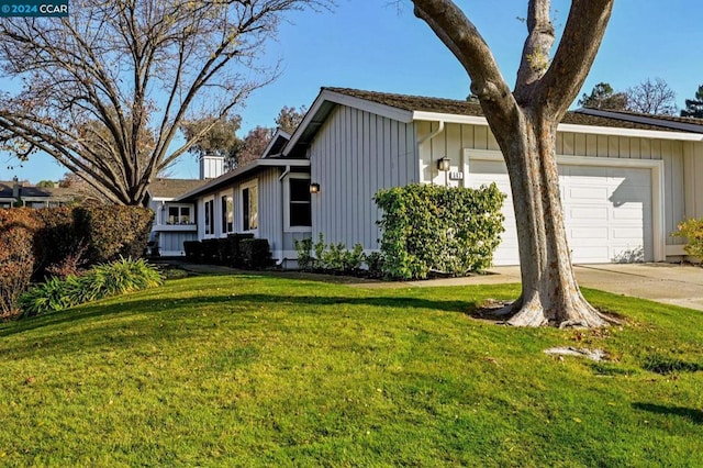 view of side of property featuring a garage and a lawn