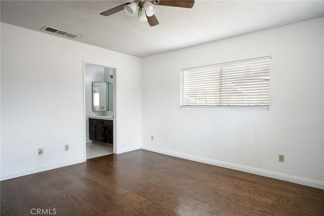 unfurnished room featuring ceiling fan, dark hardwood / wood-style flooring, and a textured ceiling