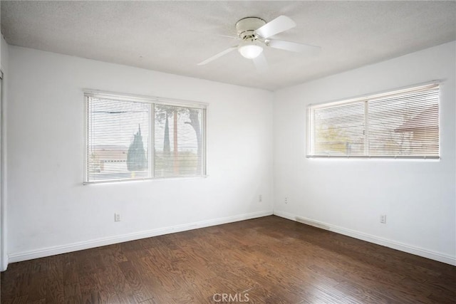 empty room with a textured ceiling, dark hardwood / wood-style flooring, and ceiling fan