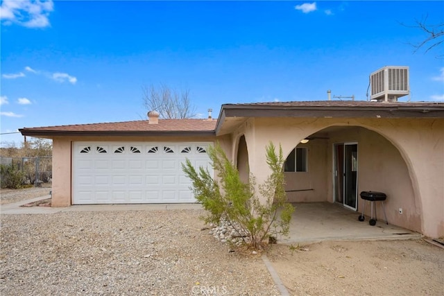 view of front of home featuring a garage and cooling unit