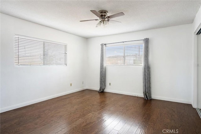 spare room featuring dark hardwood / wood-style floors, ceiling fan, and a textured ceiling