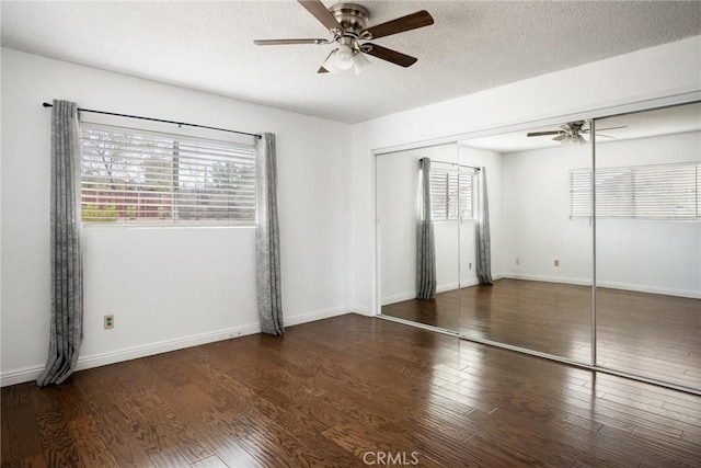 unfurnished room with a textured ceiling, ceiling fan, and dark wood-type flooring