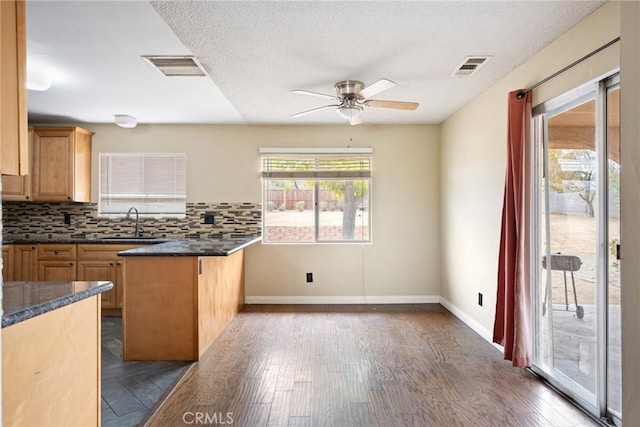 kitchen featuring sink, ceiling fan, tasteful backsplash, dark hardwood / wood-style flooring, and kitchen peninsula