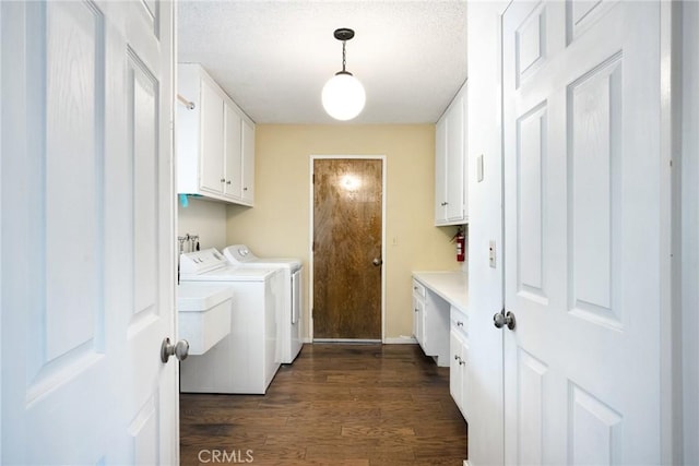 laundry area with cabinets, dark hardwood / wood-style floors, and washing machine and clothes dryer