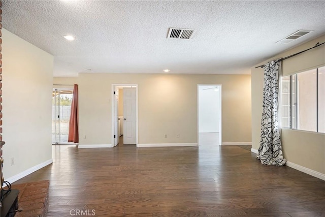 spare room with dark hardwood / wood-style flooring and a textured ceiling