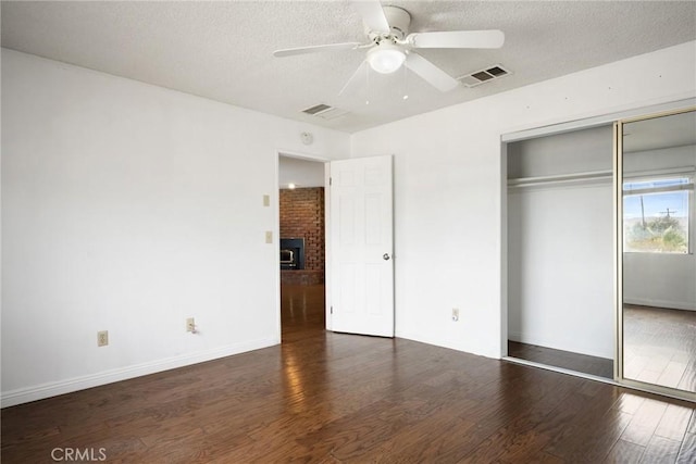 unfurnished bedroom with a closet, ceiling fan, dark hardwood / wood-style flooring, and a textured ceiling