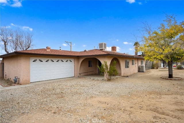 view of front of house with a garage and cooling unit