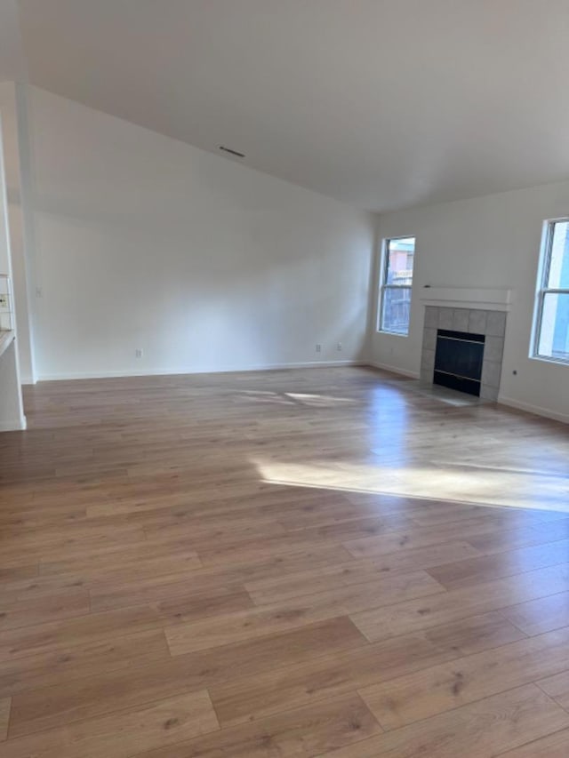 unfurnished living room with light hardwood / wood-style floors and a tile fireplace