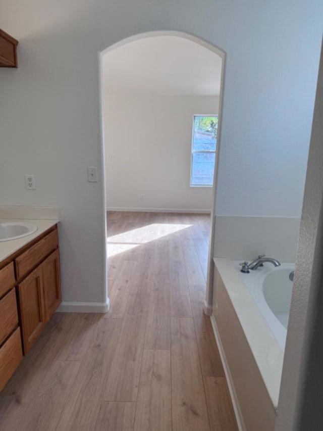 bathroom featuring hardwood / wood-style floors, a bathtub, and vanity