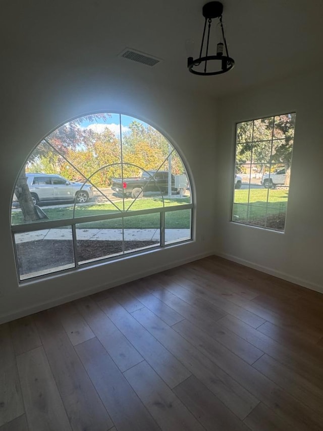 unfurnished dining area featuring a chandelier and hardwood / wood-style floors