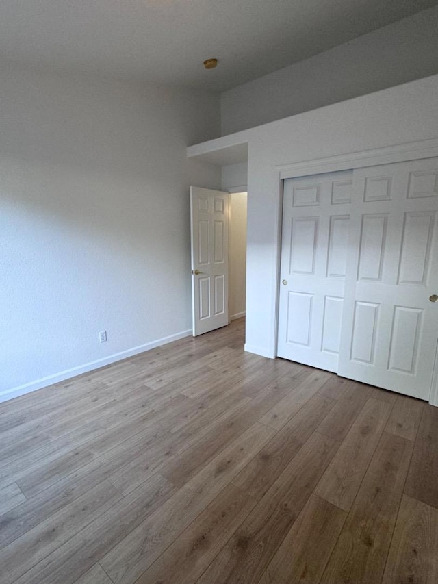 unfurnished bedroom with a closet and light hardwood / wood-style flooring