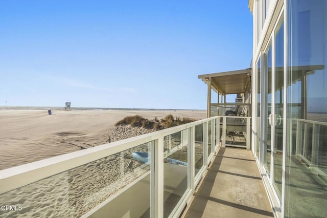 balcony with a beach view and a water view