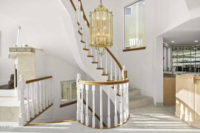 staircase featuring bar area, a towering ceiling, an inviting chandelier, and tile patterned floors