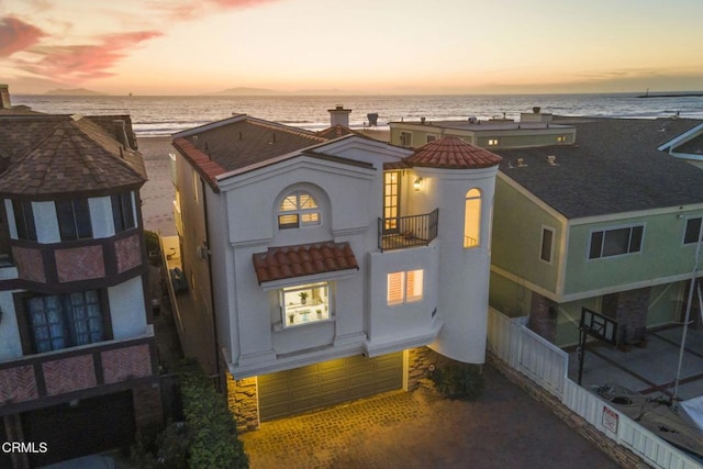 exterior space featuring a water view, a view of the beach, and a garage