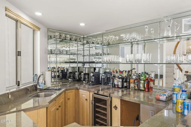 bar featuring stone countertops, wine cooler, and sink