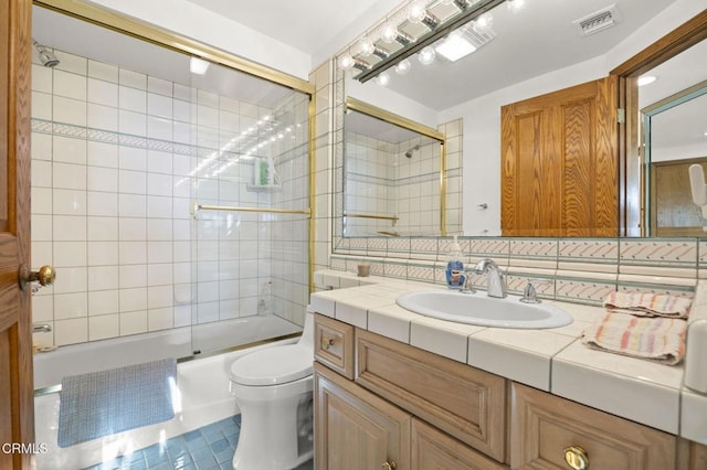 full bathroom with vanity, tile patterned floors, toilet, enclosed tub / shower combo, and tasteful backsplash