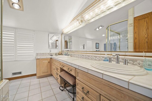 bathroom with tile patterned flooring, vanity, an enclosed shower, and lofted ceiling