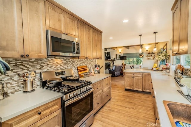 1181 Voltaire Dr, Lake Arrowhead, CA 92352 - kitchen featuring appliances with stainless steel finishes, light wood-style floors, a peninsula, decorative backsplash, and recessed lighting