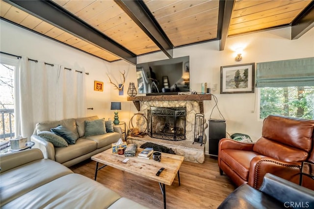 living room featuring beam ceiling, wood-type flooring, a fireplace, and wood ceiling