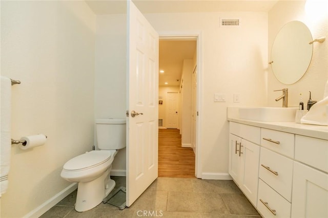 bathroom with wood-type flooring, vanity, and toilet