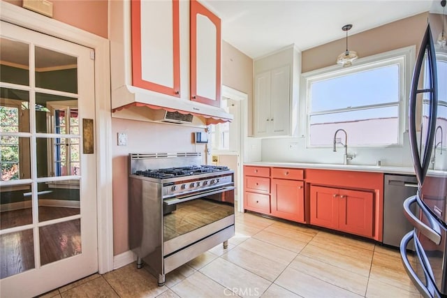 kitchen with appliances with stainless steel finishes, ceiling fan, sink, light tile patterned floors, and pendant lighting