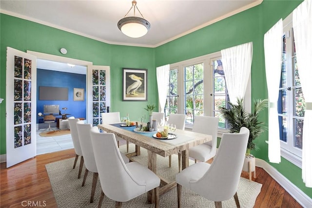 dining space with hardwood / wood-style floors and crown molding