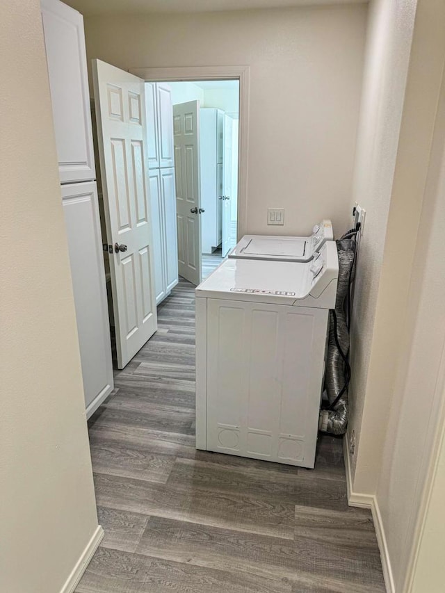 laundry room with separate washer and dryer, cabinets, and dark wood-type flooring