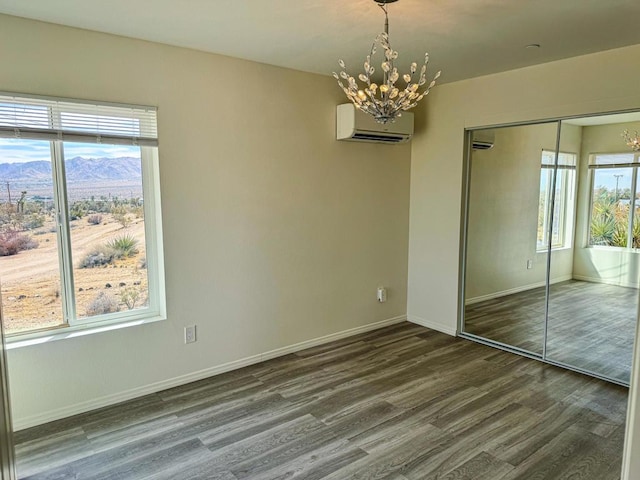 unfurnished bedroom with a mountain view, an inviting chandelier, multiple windows, and a closet