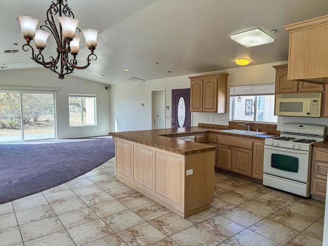 kitchen with plenty of natural light, light colored carpet, white appliances, and vaulted ceiling