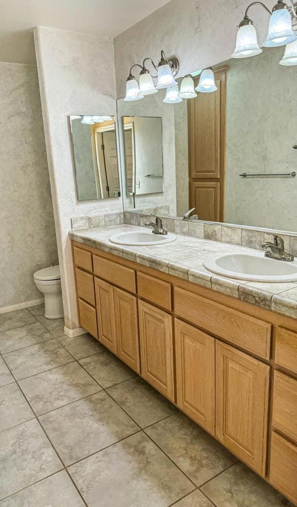 bathroom with tile patterned flooring, vanity, and toilet