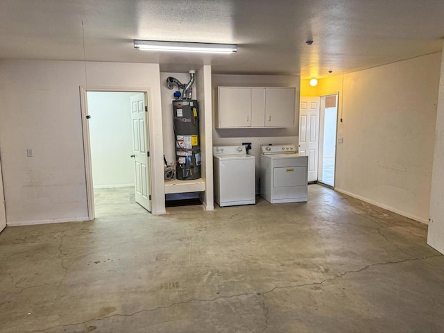 interior space featuring cabinets, a textured ceiling, strapped water heater, and washer and clothes dryer