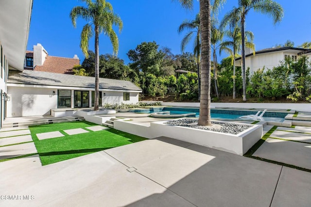 view of swimming pool featuring a patio area and an in ground hot tub