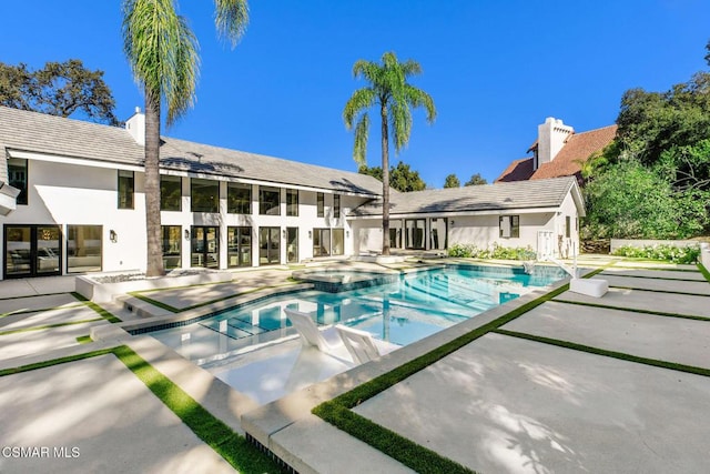 view of swimming pool featuring a patio area and an in ground hot tub