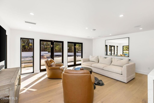 living room with french doors and light hardwood / wood-style floors